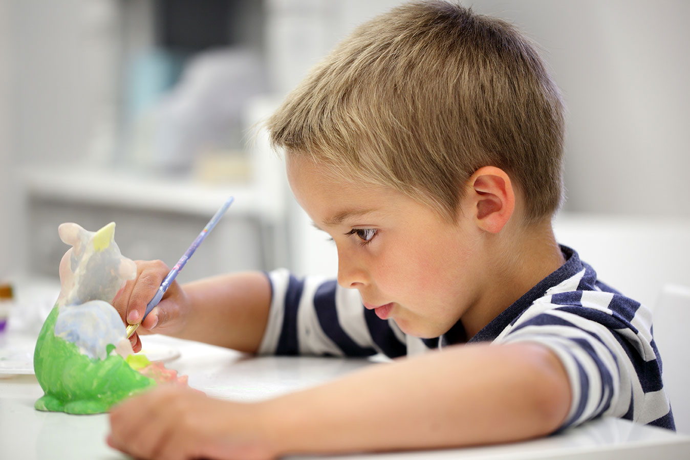 AdobeStock_65942734 Kind beim Keramikmalen im Keramikmalstudio Eigenlob